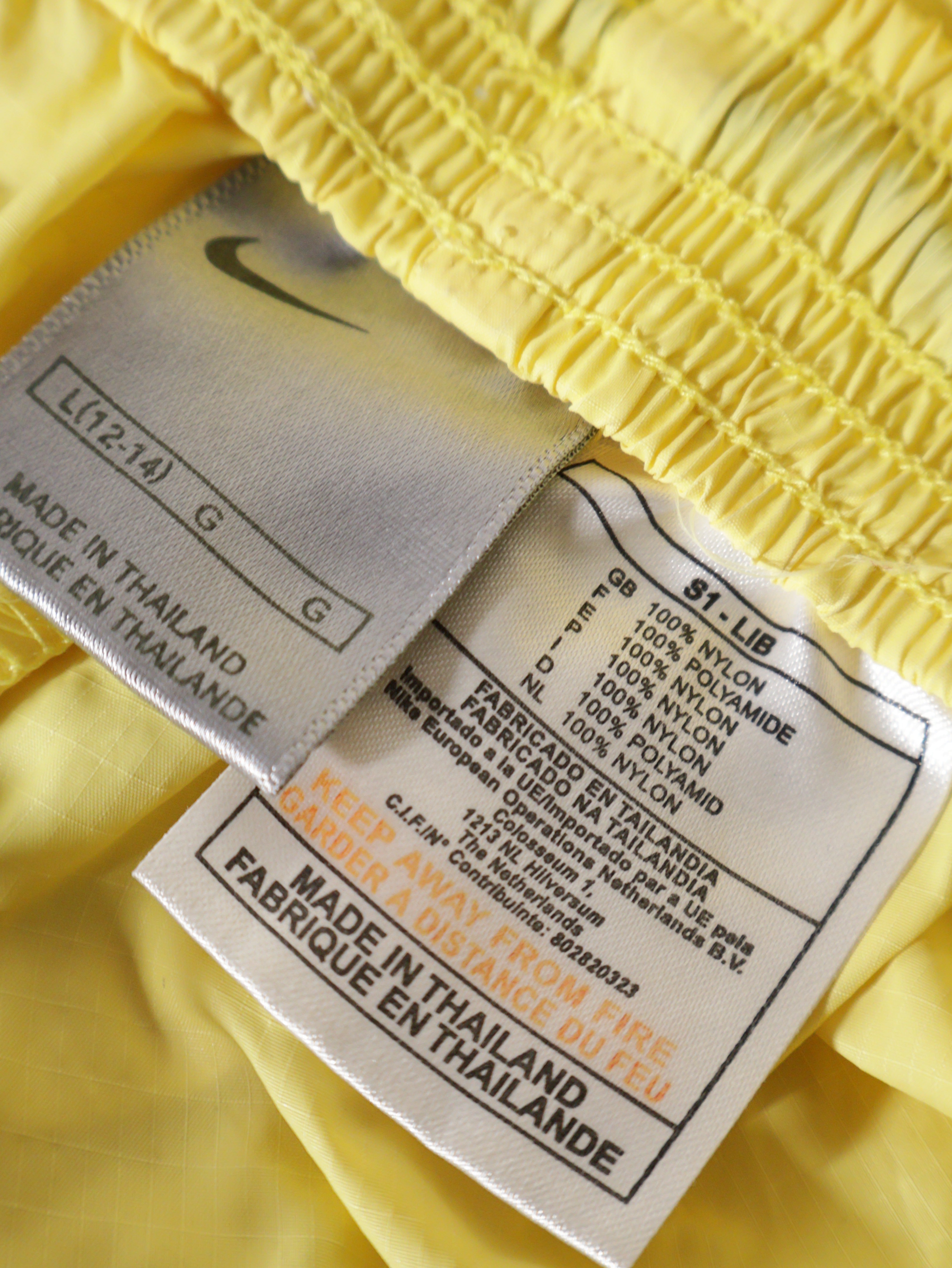 Eticheta marime si compozitie (rotita dreapta) - Pantaloni NIKE galbeni din nylon – L – Femei