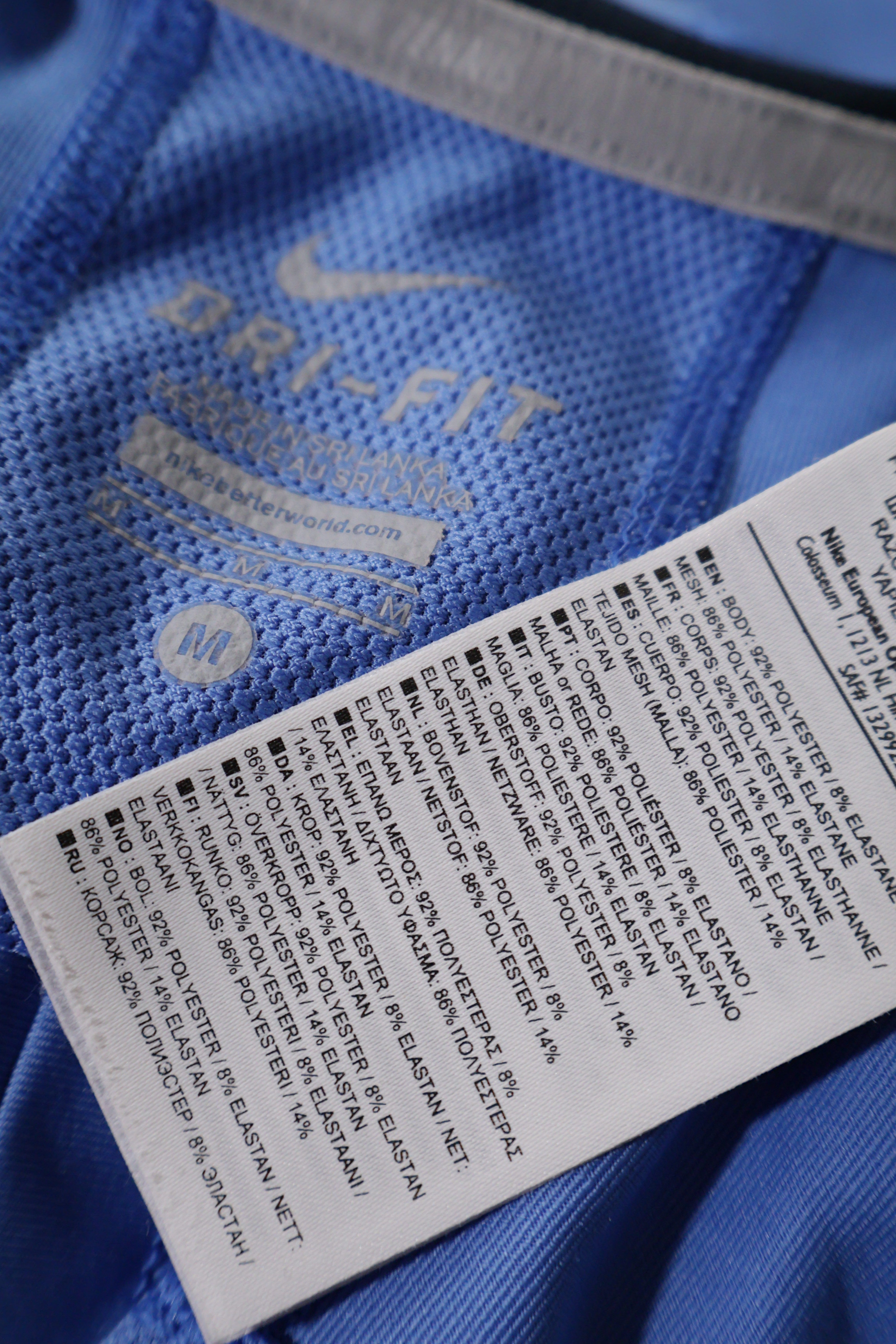 Eticheta marime si compozitie (rotita dreapta) - Maiou - NIKE albastru deschis Dri-FIT cu inserții bleumarin – M – Femei