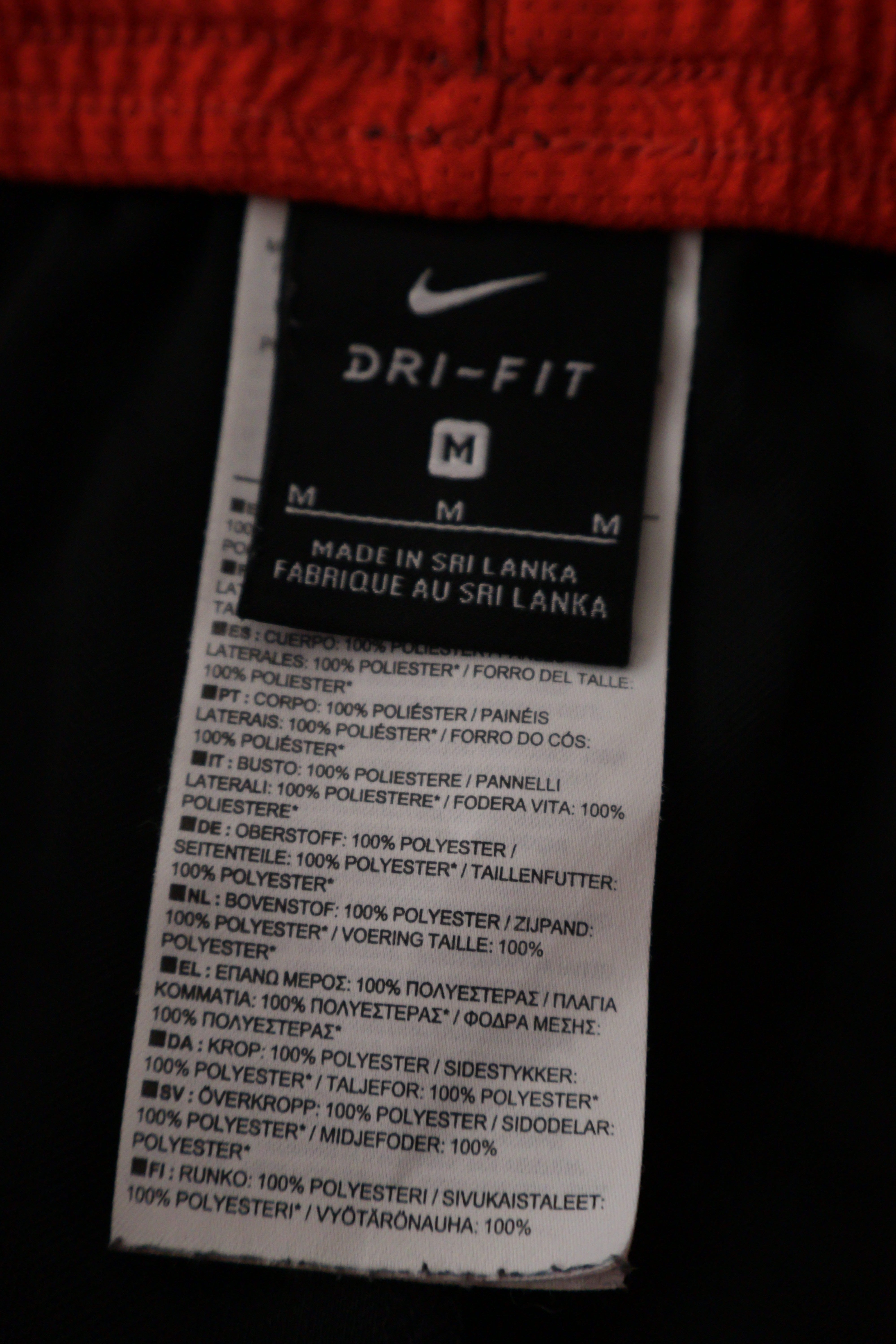 Eticheta marime si compozitie (rotita dreapta) - Pantaloni scurți - NIKE negri cu insertii rosii si croiala sport – M – Bărbați